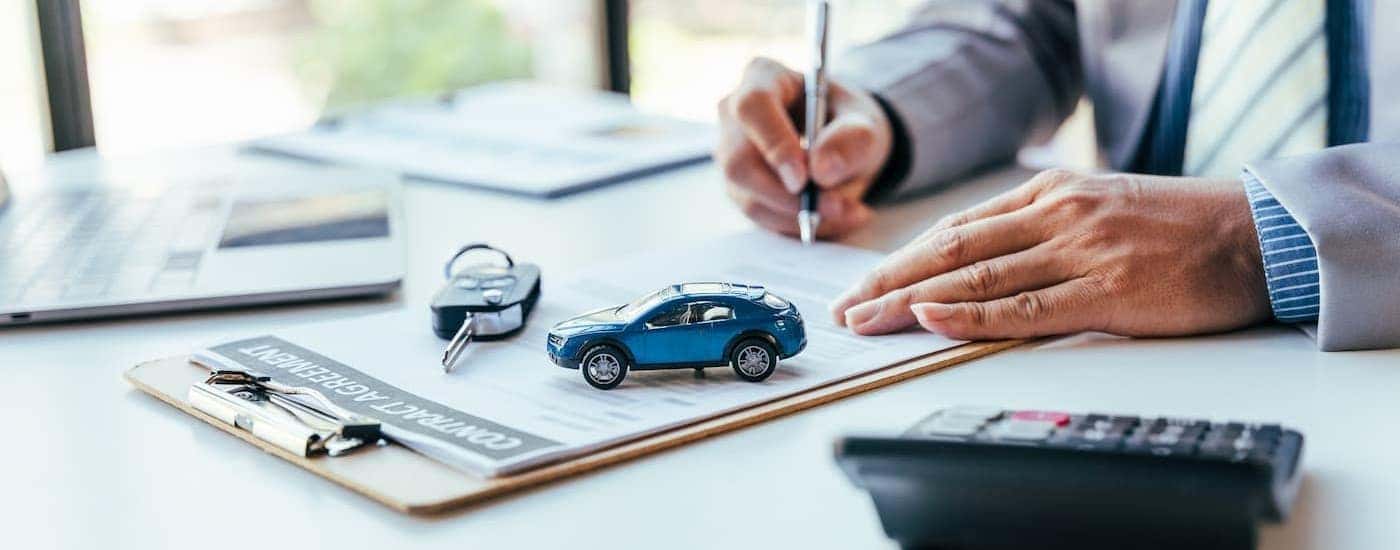 A person signing papers at a Ford dealer near Florence.