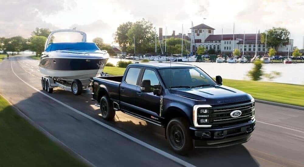A black 2025 Ford F-250 towing a boat.