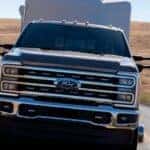 A black 2025 Ford Super Duty towing a camper behind