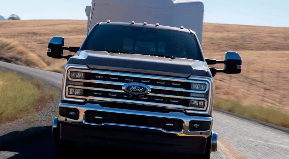 A black 2025 Ford Super Duty towing a camper behind