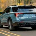 A blue 2025 Ford Explorer driving on a highway.