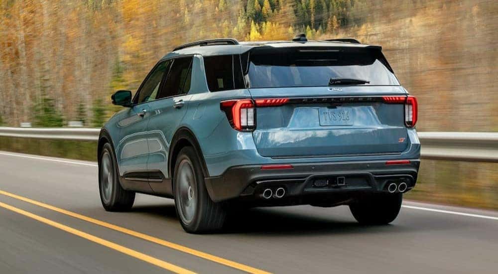 A blue 2025 Ford Explorer driving on a highway.