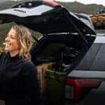 A person standing at the rear of a gray 2026 Ford Explorer.