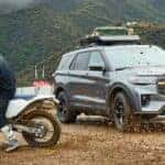 A blue 2026 Ford Explorer Tremor parked near a dirt bike.
