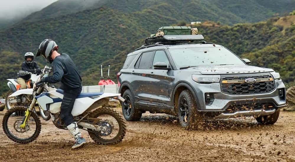 A blue 2026 Ford Explorer Tremor parked near a dirt bike.