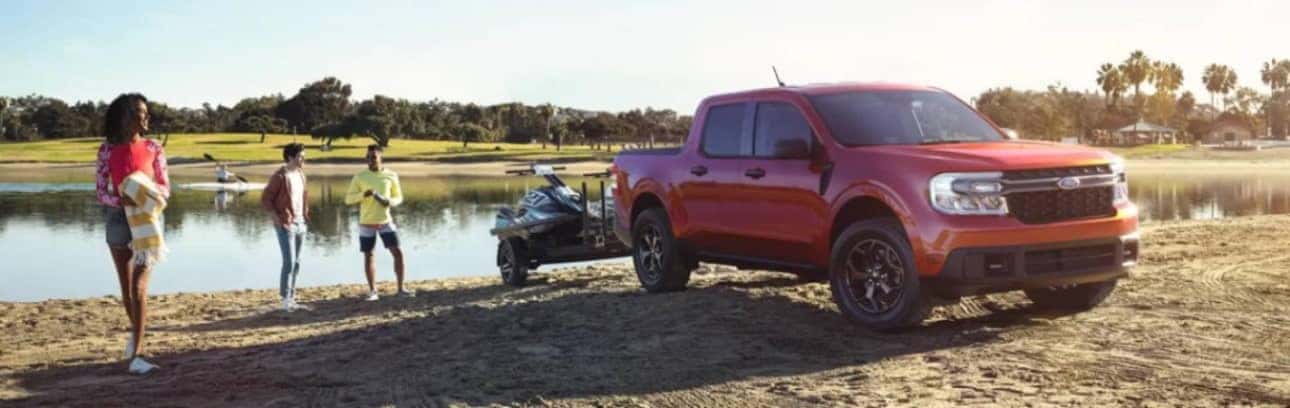 People hanging out by a lake and a parked Ford truck with wave jammer attached