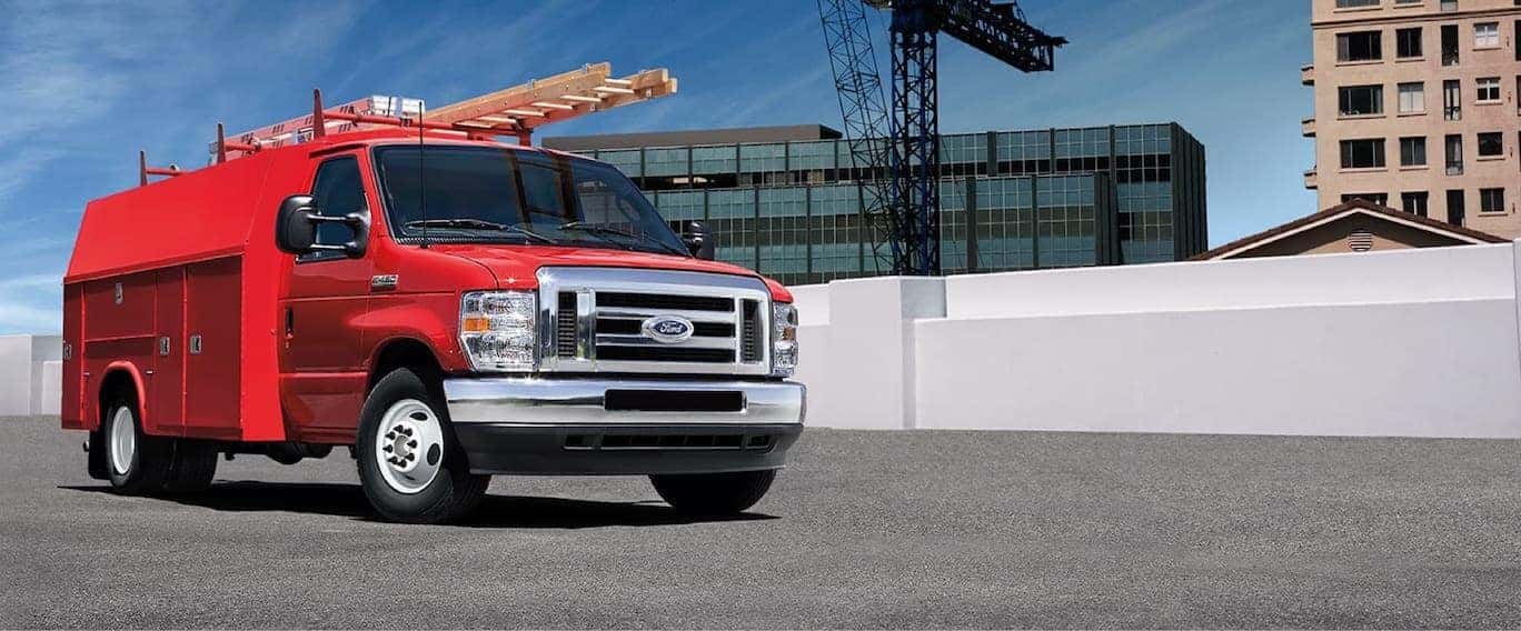 Red Ford truck driving down the road