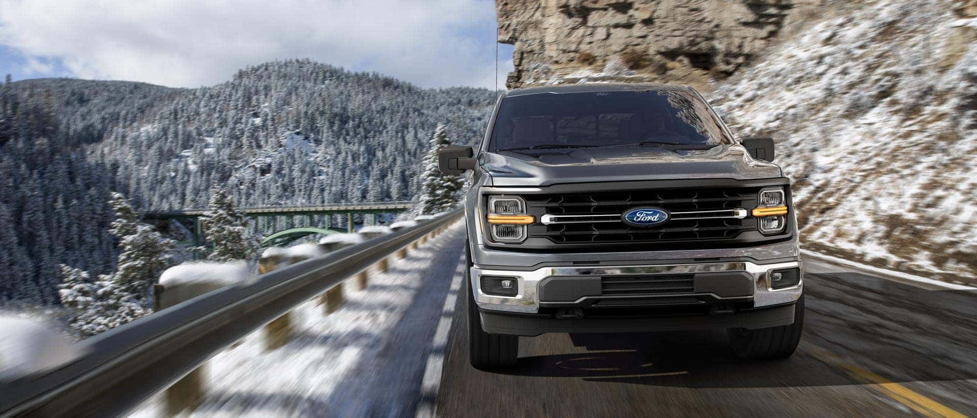 Front view of the 2026 Ford F-150 on a snowy highway showing bold grille design