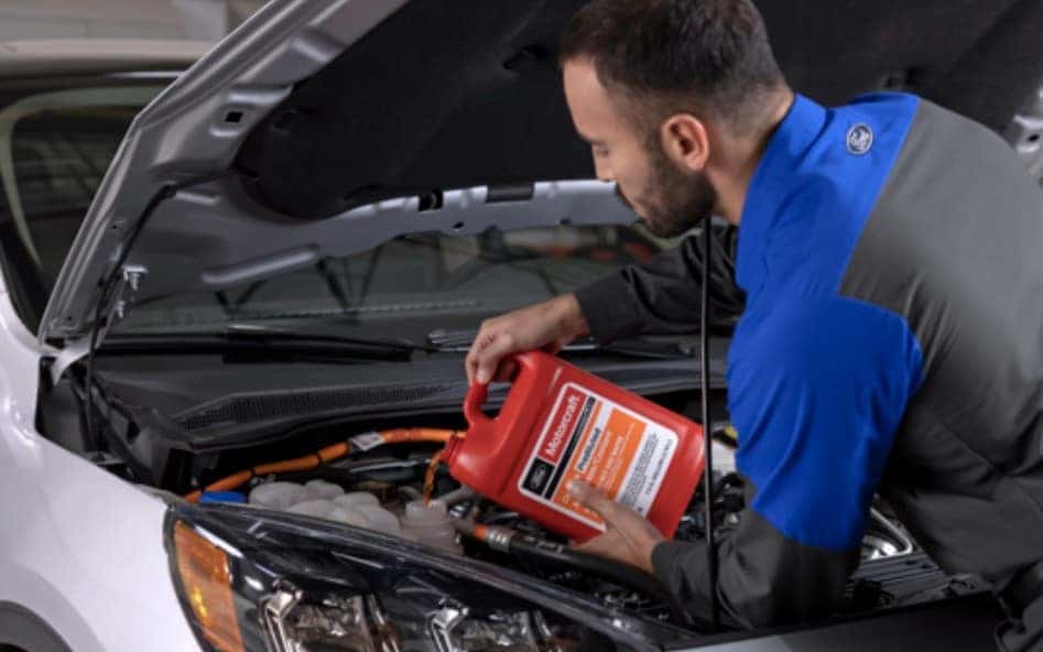 Ford service technician checking engine fluids during winter inspection
