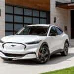 White Ford Mustang Mach-E SUV Outside Garage House