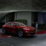 Red Ford Mustang Mach-E SUV Four People Outside Lights Door