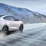 White Ford Mustang Mach-E EV SUV Snow Mountain