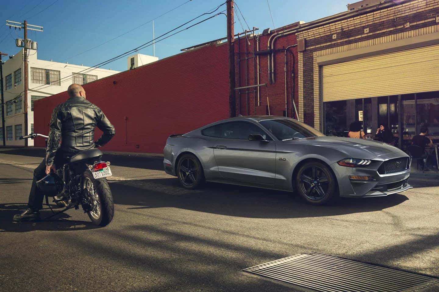 Gray Ford Mustang Motorcycle Man Buildings