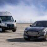 Gray Ford Transit Van and Gray Mustang MAch-E EV SUV Blue Sky