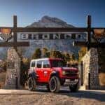 Person Brown Dirt Mountains Red, White, Blue Ford Bronco Sport SUV