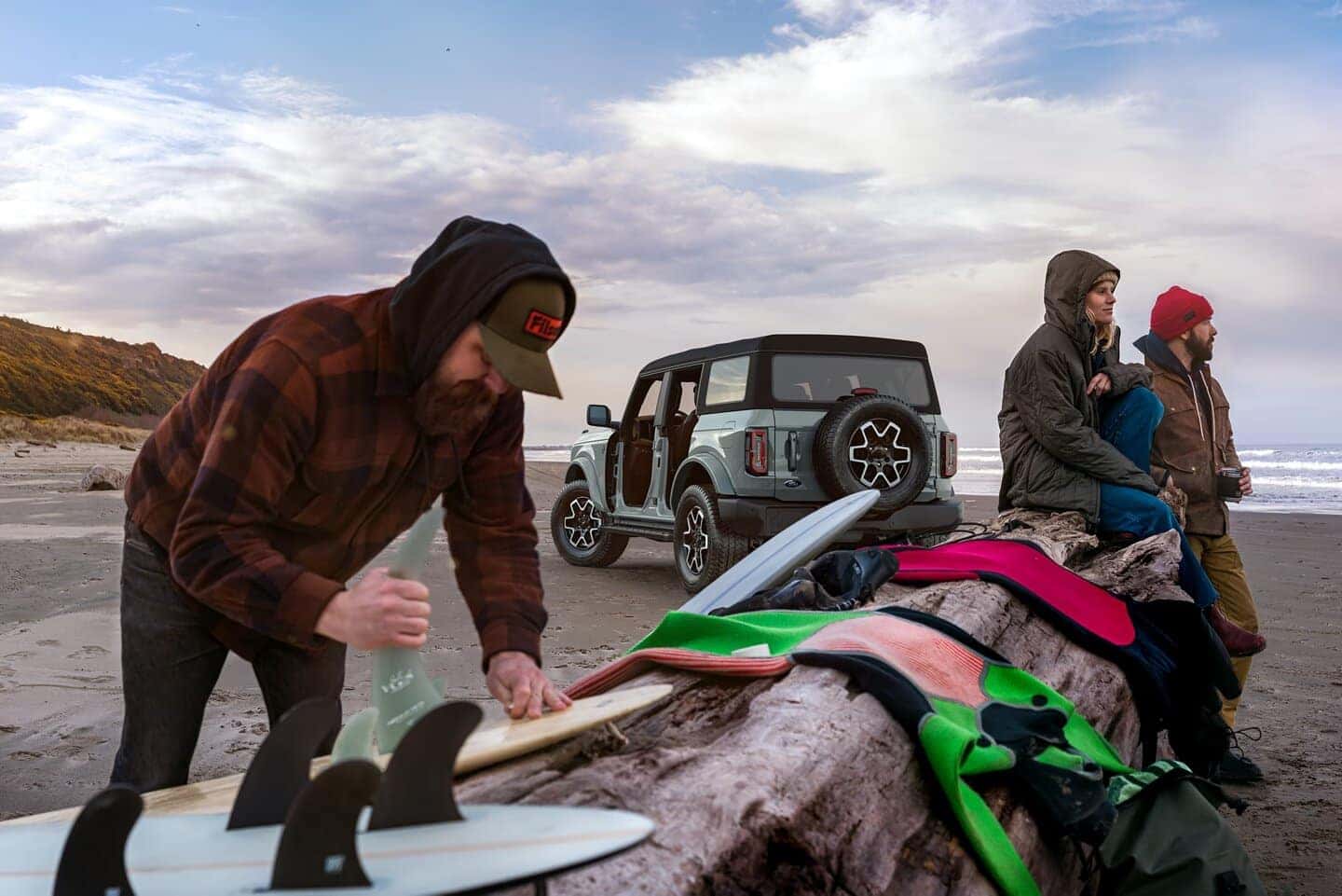 People Blankets Surf Boards Blue Ford Bronco SUV Sand