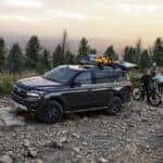 Black Ford Expedition SUV Trees Rocks People Kayak