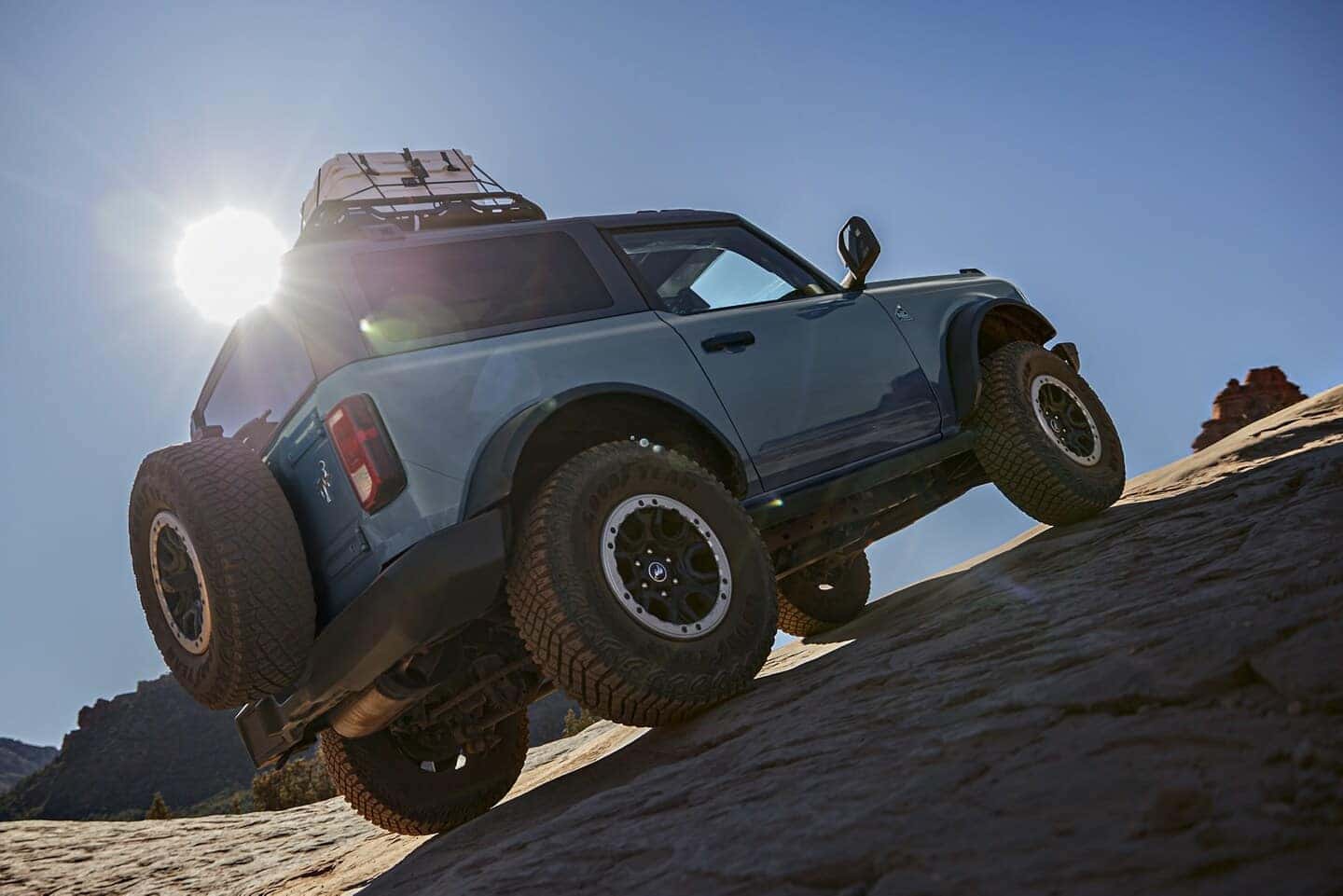 Blue Ford Bronco SUV Brown Hill Mountain Sun