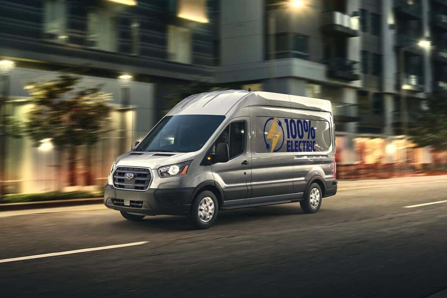 Gray Ford E-Transit Van open road lights building  