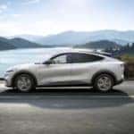 Ford Mustang Mach E SUV white open road mountains lake