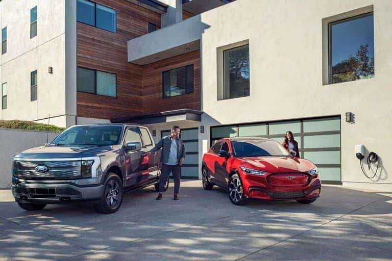 Gray Ford F-150 Pickup Red Mustang Mach-E Men and Women Outside House