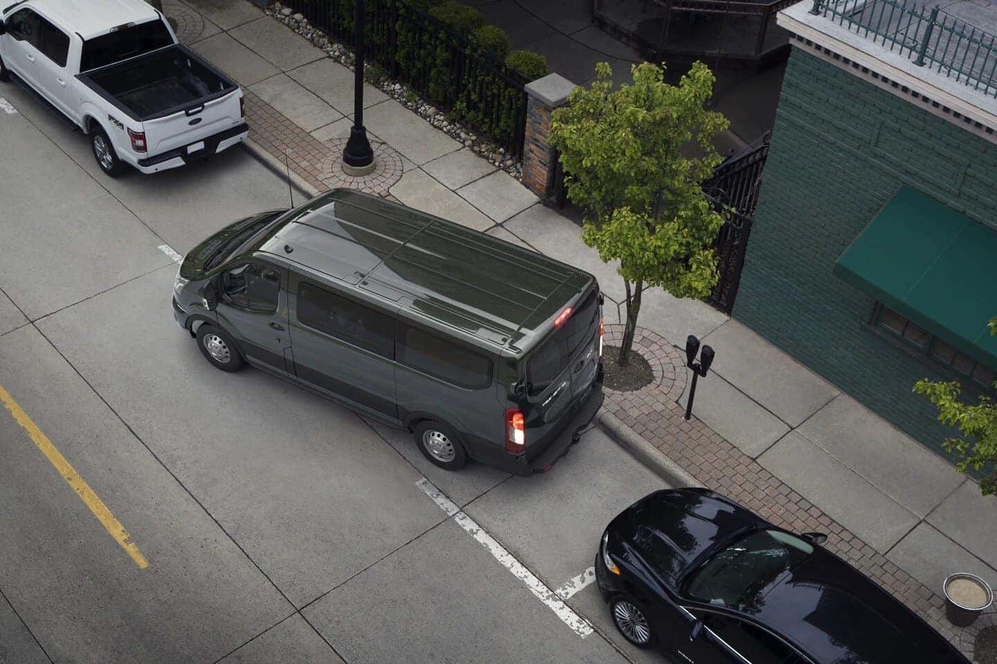 Gray Ford Transit Van White Pickup Black Sedan Street Tree