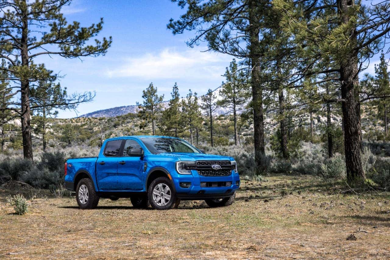 Blue Ford Ranger Pickup Outside Trees Mountains