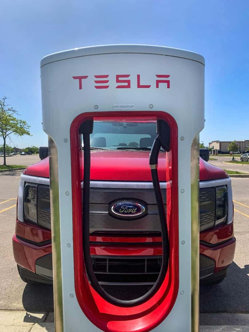 Red Ford F-150 Lightning Pickup Tesla Charging Station