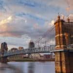 Stone bridge over water in front of tall Cincinnati Ohio