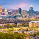 A river with a bridge going over it surrounded by tall Cincinnati, OH buildings