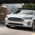 A white Ford Fusion from Ford Dealers in Ohio driving on a city street