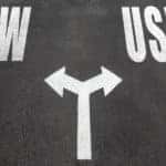 New vs used choice concept, two direction arrows on asphalt.