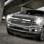 Silver 2018 Ford F150 on road under bridge