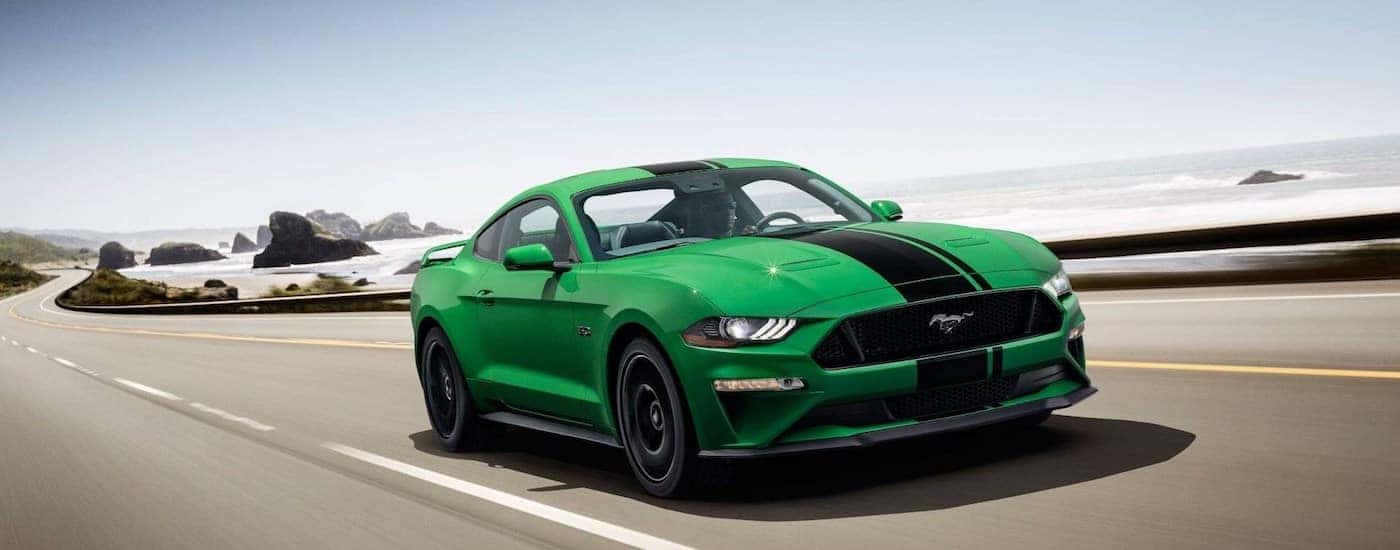A bright green 2019 Ford Mustang speeds down a empty highway