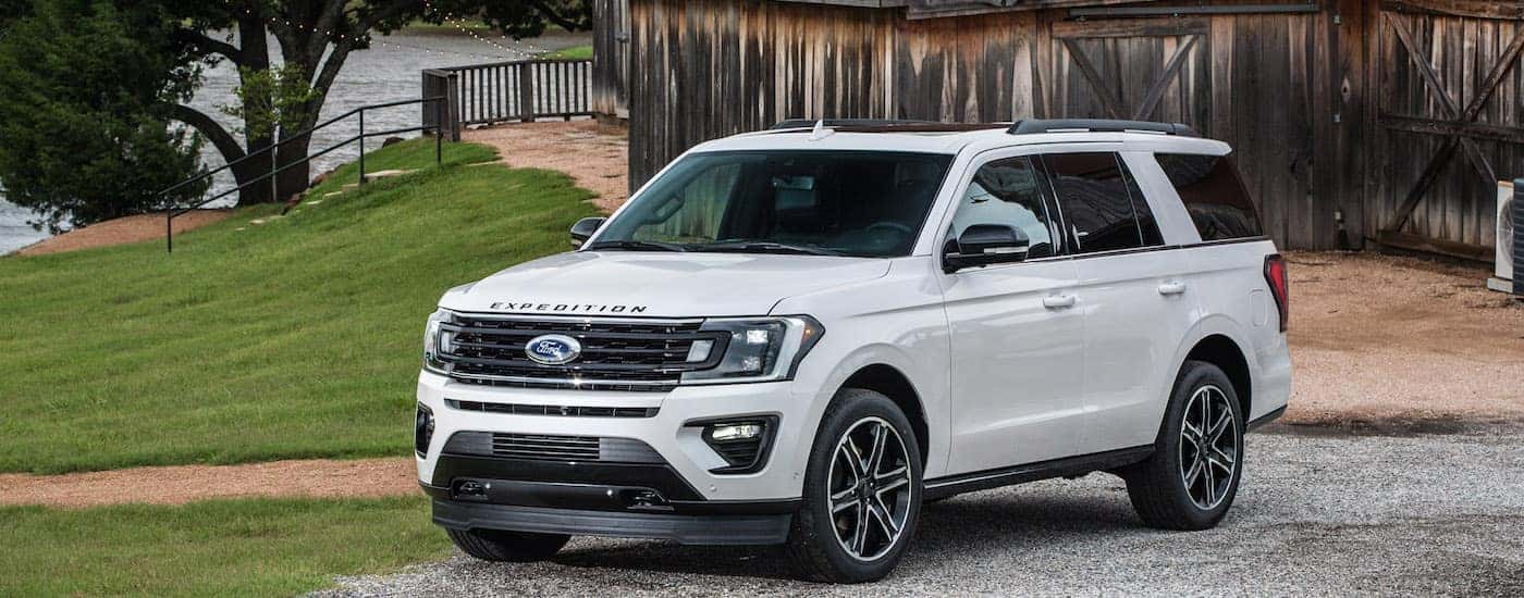 White 2019 Ford Expedition Limited in front of a barn and lake