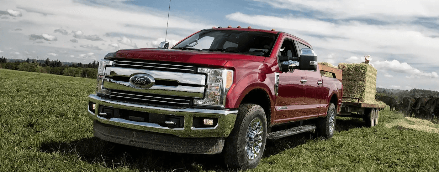 A red 2019 Ford F250 towing hay