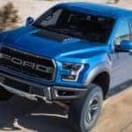 A blue 2019 Ford F150 Raptor cruising in the desert