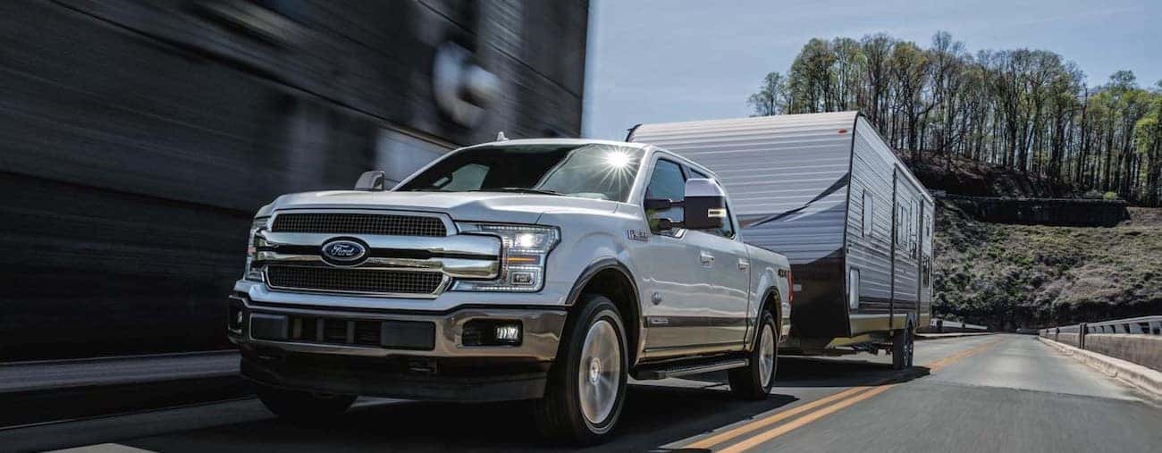 A 2019 Ford F-150 towing a large RV down a road.