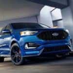A blue 2019 Ford Edge is driving through a parking garage.