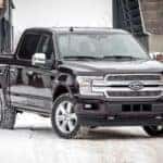 A black 2018 Ford F150 is parked in the snow.