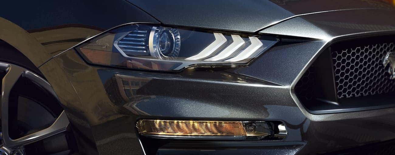 The headlight of a grey 2020 Ford Mustang is shown.