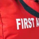 A red bag that says First Aid Kit in white lettering.