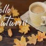 A coffee cup next to leaves with the saying, "Hello Autumn."
