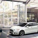 A white 2016 Ford Fusion is parked in front of an office building outside of Cincinnati, OH.