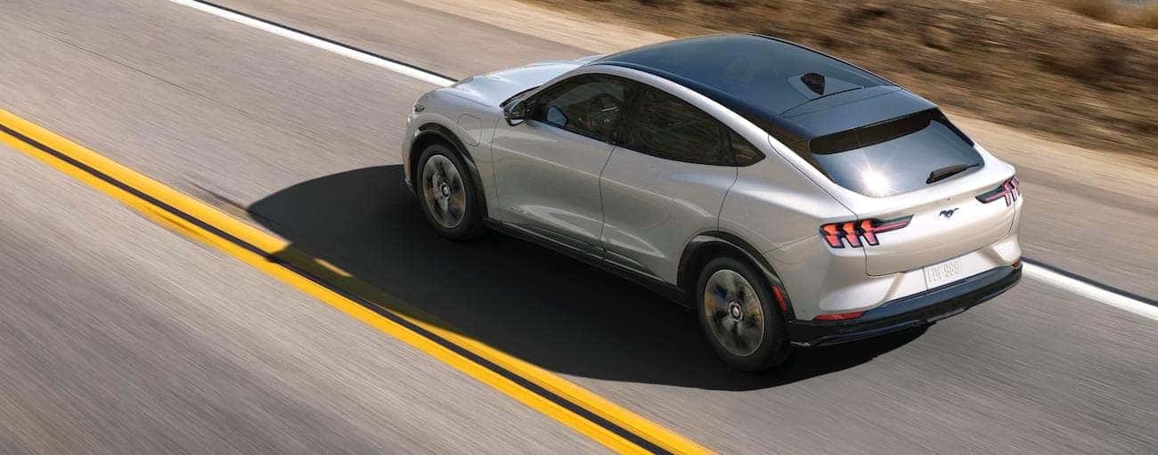 A white 2021 Ford Mustang Mach-E is shown driving from above.