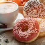 Donuts are next to a mug of coffee at a Cincinnati, OH cafe.