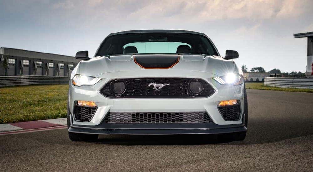 A white 2021 Ford Mustang Mach 1 is shown from the front while parked on a race track.