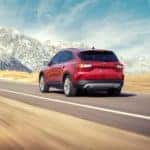 A red 2020 Ford Escape is driving towards a large snow covered mountain outside of Cincinnati, OH.