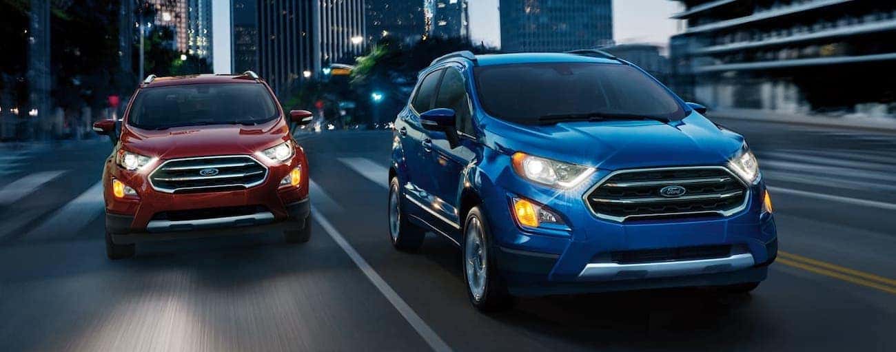 A red and a blue 2020 Ford EcoSport are driving outside Cincinnati, OH, at night.