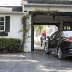 A popular Ford in Cincinnati, OH, a black 2020 Ford Fusion Hybrid, is shown charging in front of a white house.